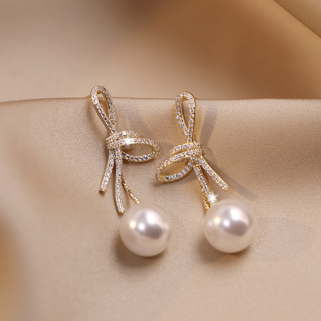 Gold Bow Pearl Earrings with a Dazzling Finish