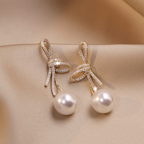 Gold Bow Pearl Earrings with a Dazzling Finish